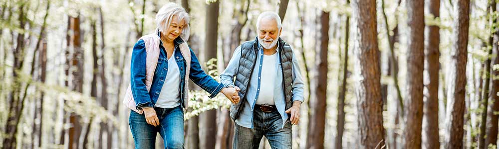 older couple hiking in the woods