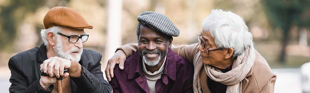 three older men sitting in a park