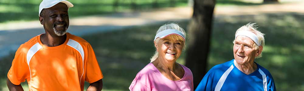 three people power walking in the park