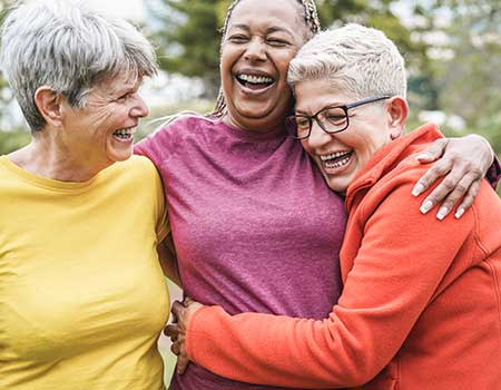 three happy ladies hugging